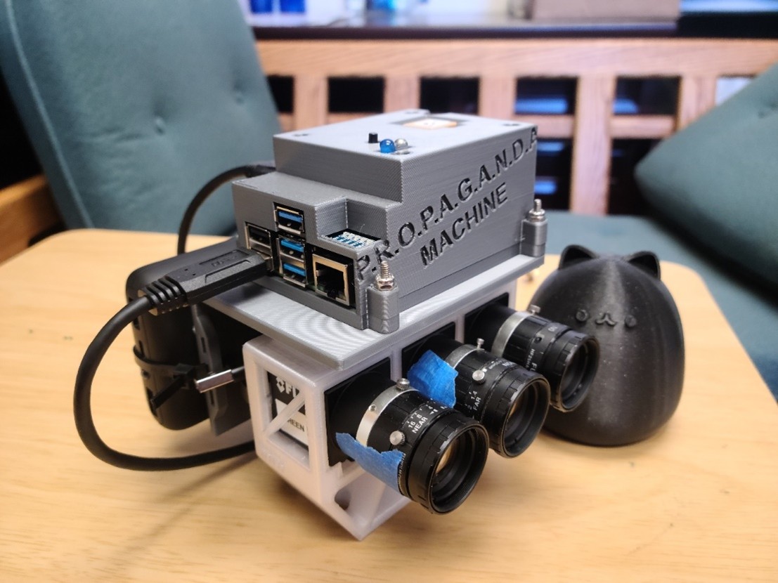 A device with lenses on one side, and wires coming out of it.